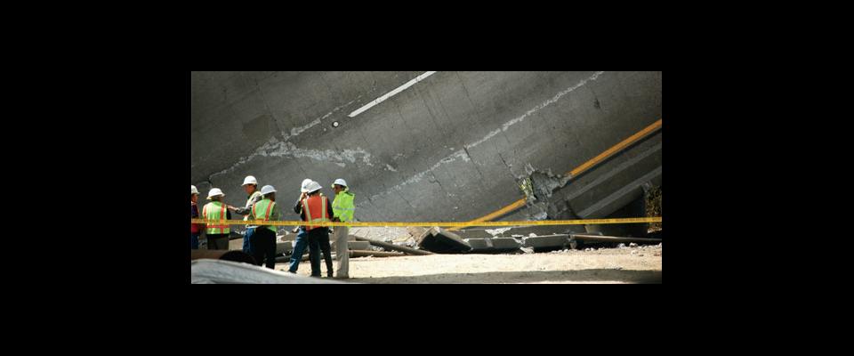 construction workers in front of a collapsed freeway