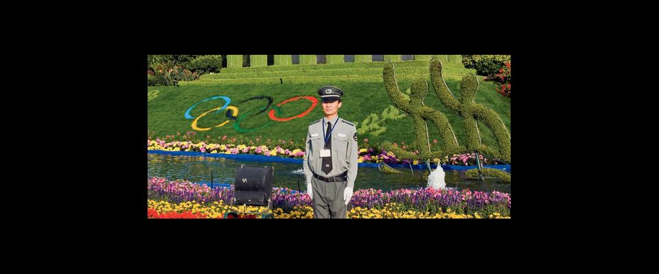 Chinese guard standing in front of Olympic Rings