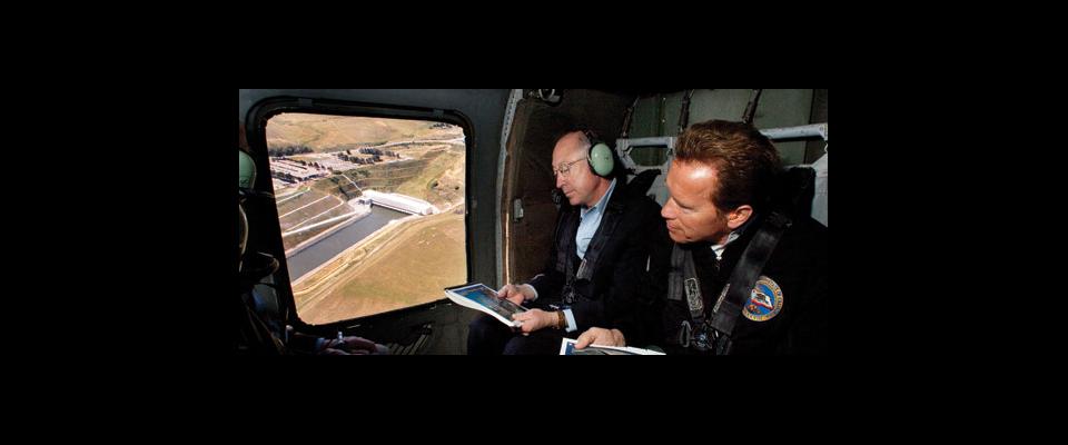 photograph of Arnold Swarzenegger and another man in an airplane
