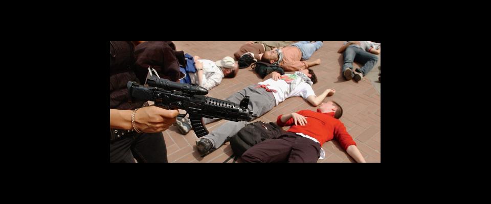 protesters playing dead and a man holding a gun