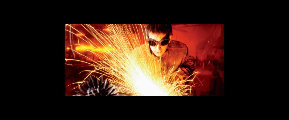 a man welding in goggles with sparks flying