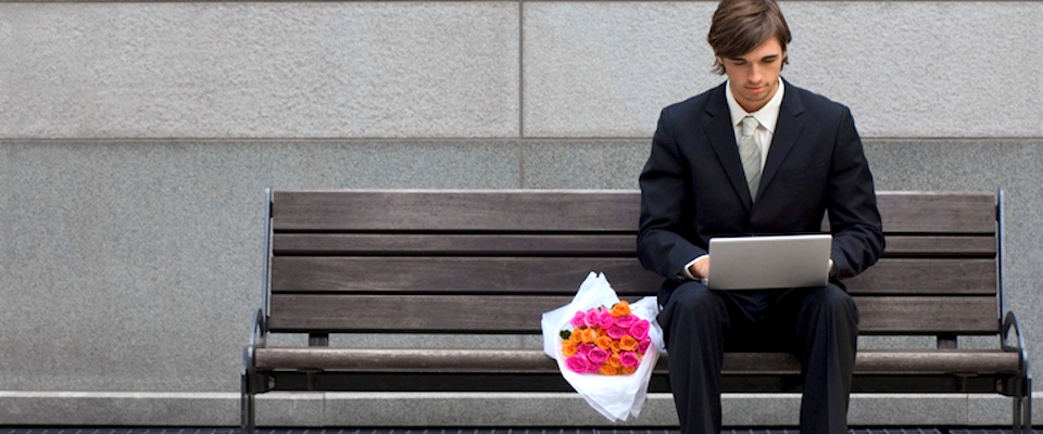 Man sitting on bench next to flowers