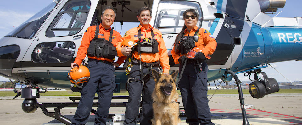 Search and Rescue team members standing in front a helicopter