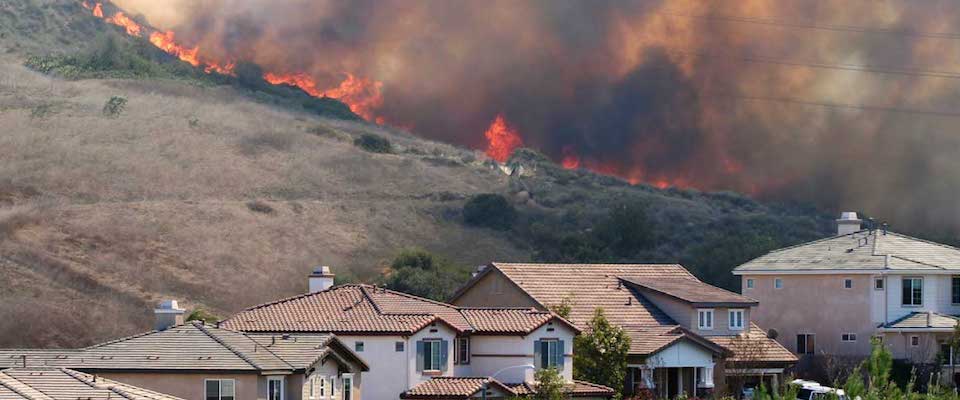 wildfire behind some houses