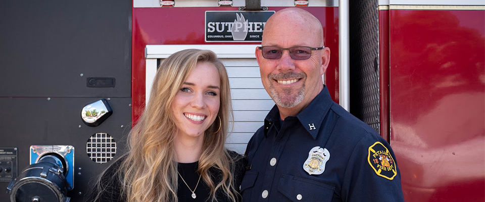 Bailey Farren and her father in front of a firetruck