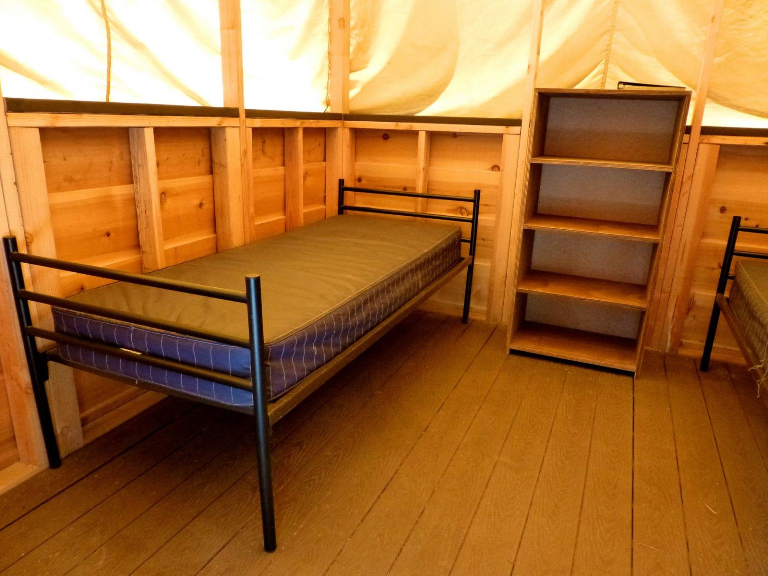 two twin beds with a wooden bookshelf