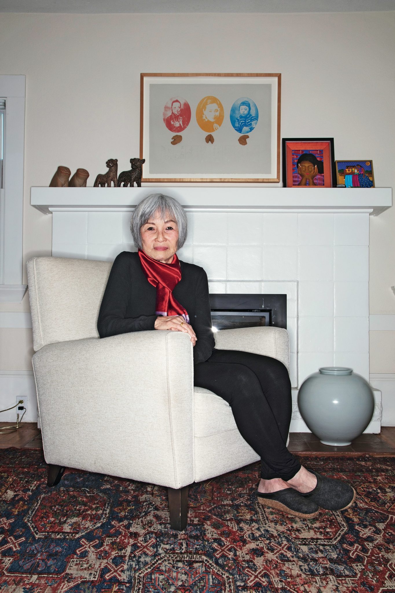 Cal alumna Elaine Kim seated in front of fireplace in living room