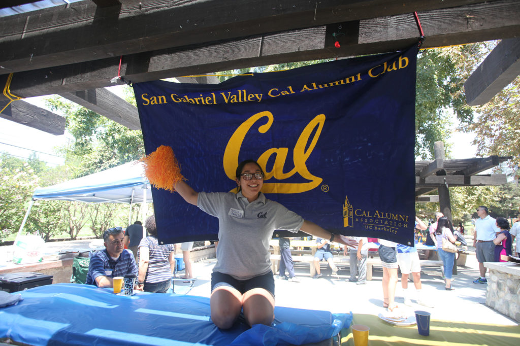 Alumni posing in front of San Gabriel Valley Cal Alumni Club flag
