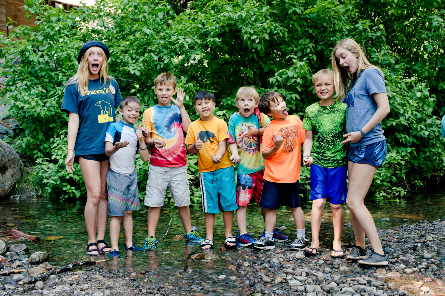 Kids and staffers making funny faces in the creek