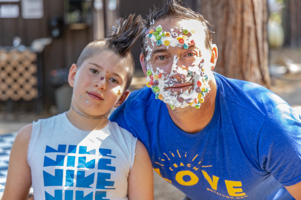 Man with cereal on his face with his son