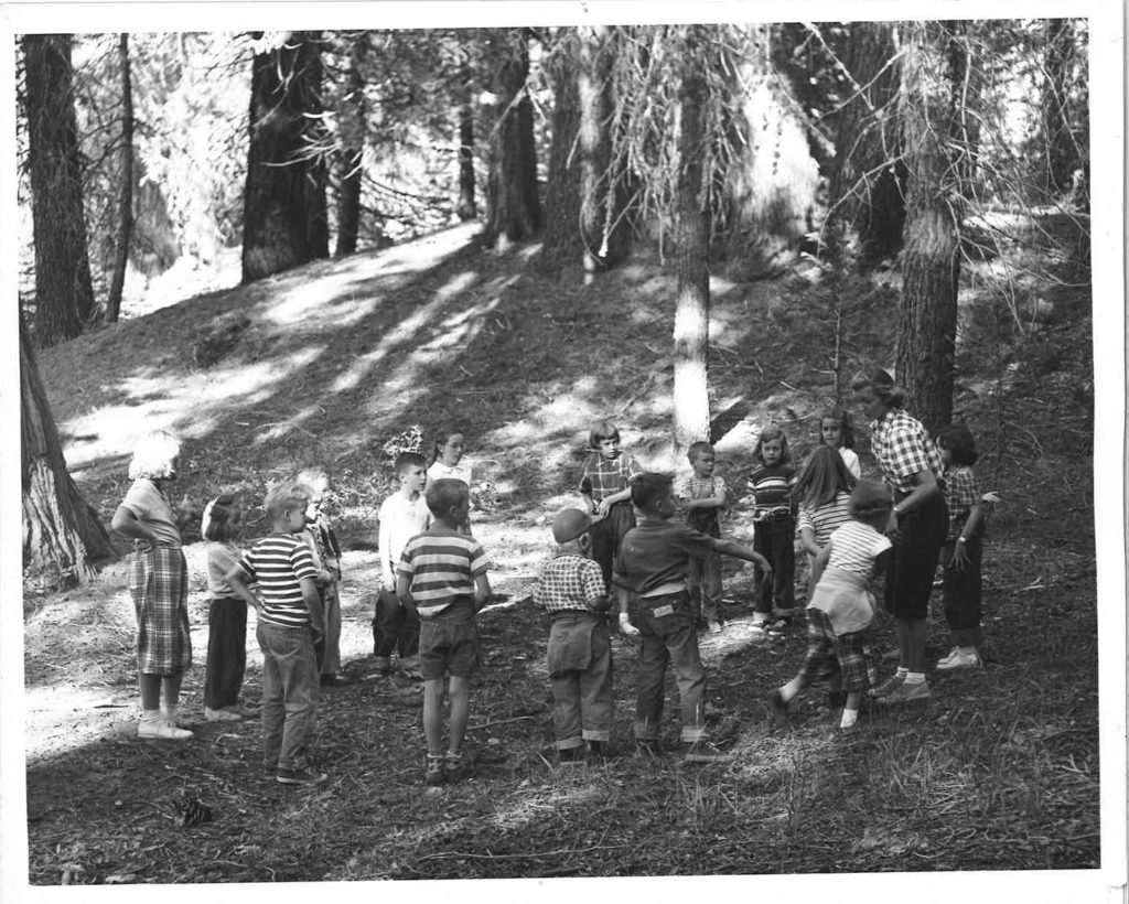 old lair staff in woods leading kids activity