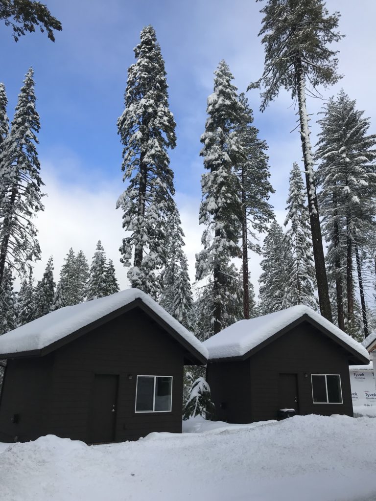 Brown winterized cabins covered in snow