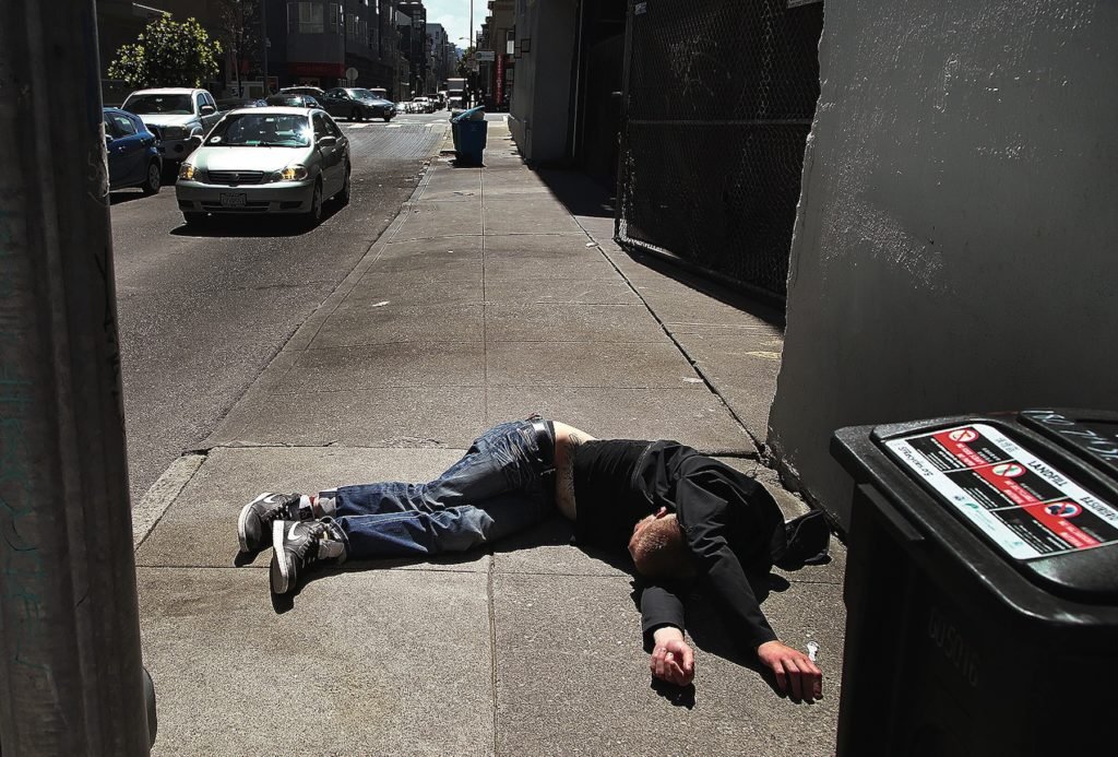 A man passed out on the sidewalk
