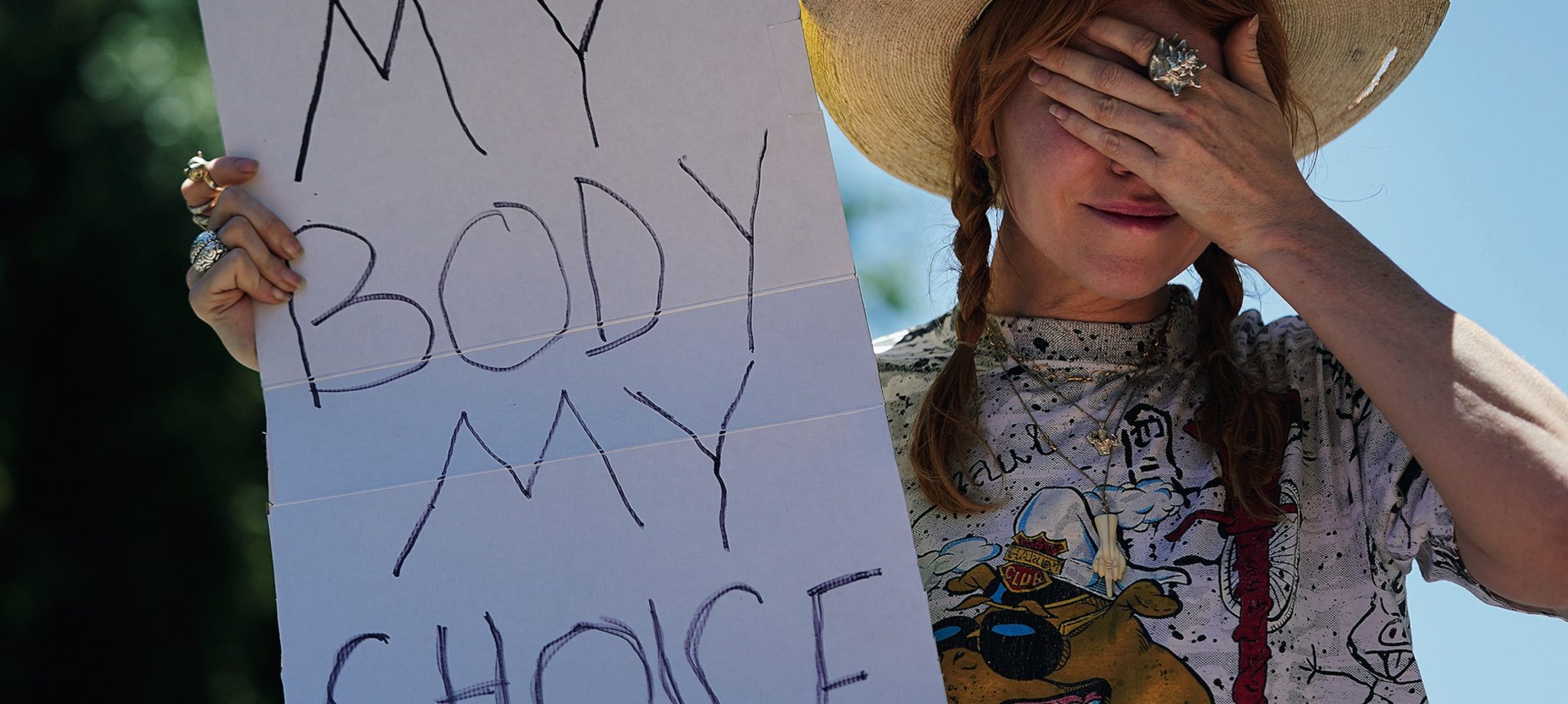 Emotional woman carrying "My body my choice" sign