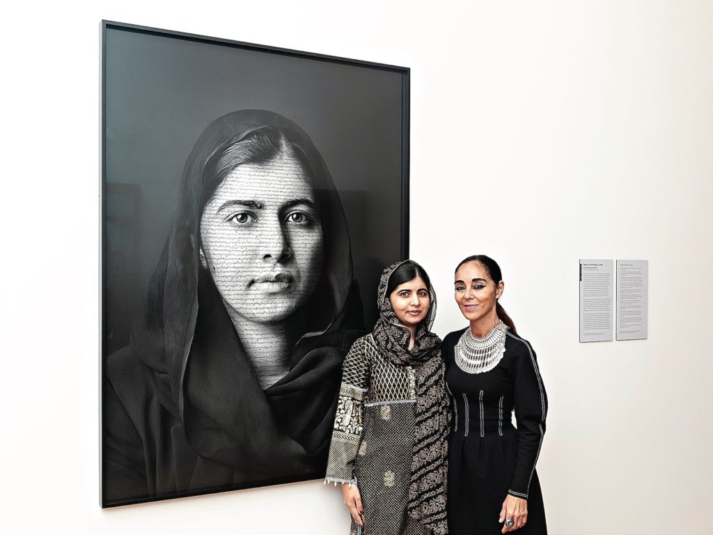 Neshat with subject Malala Yousafzai, 2014 Nobel Peace Prize recipient, in front of her portrait