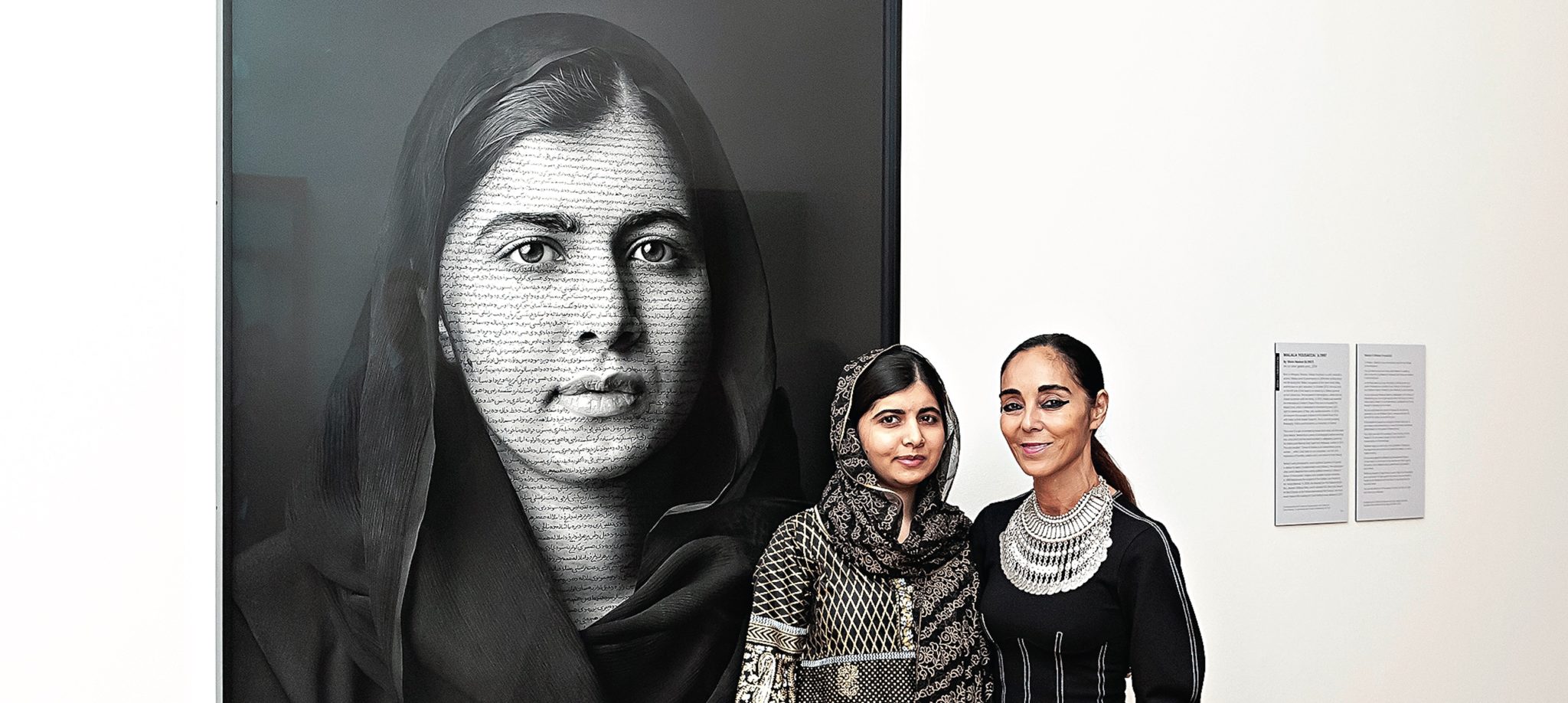 Shirin Neshat (right) with subject Malala Yousafzai, 2014 Nobel Peace Prize recipient, in front of Neshat's painting