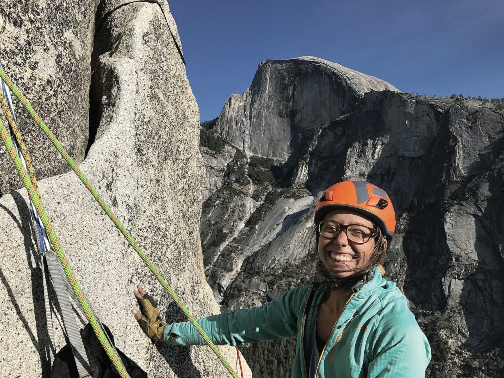 Lauren DeLaunay Miller smiling while climbing a mountain in Yosemite