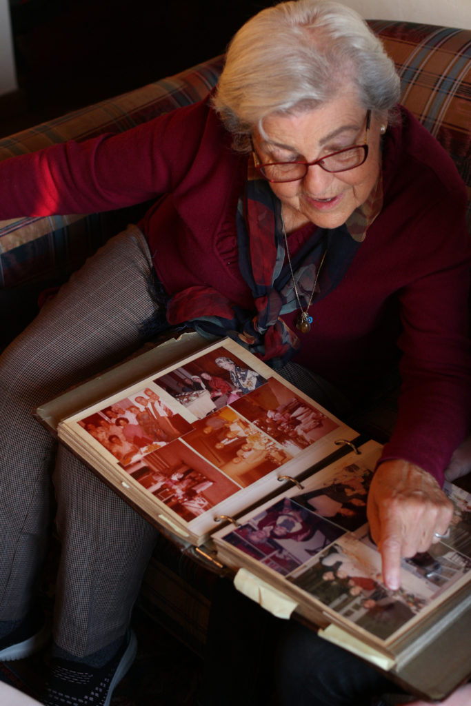 Rebecca Contopoulou pointing at a picture in her family album