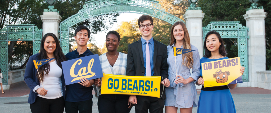 Six Leadership Award scholars holding Cal signs stand in front of Sather Gate.