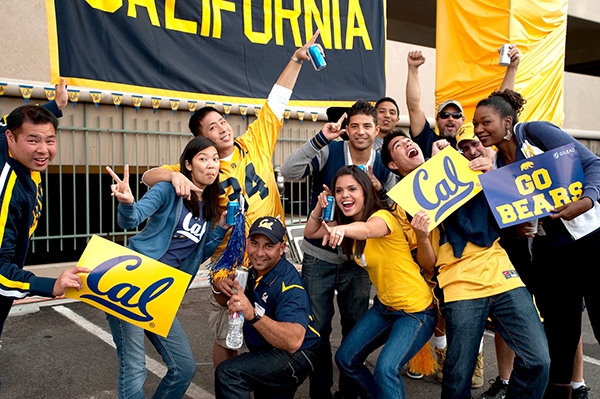 A group of Cal Alumni having fun and holding Cal signs at a Chapter gathering.