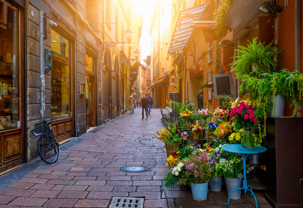 Old narrow street with flower shop in Bologna