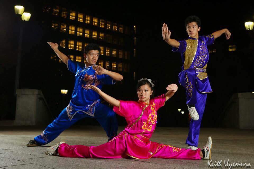 Siblings Chrystina, Michael, and Robert Yu doing Wushu poses. 
