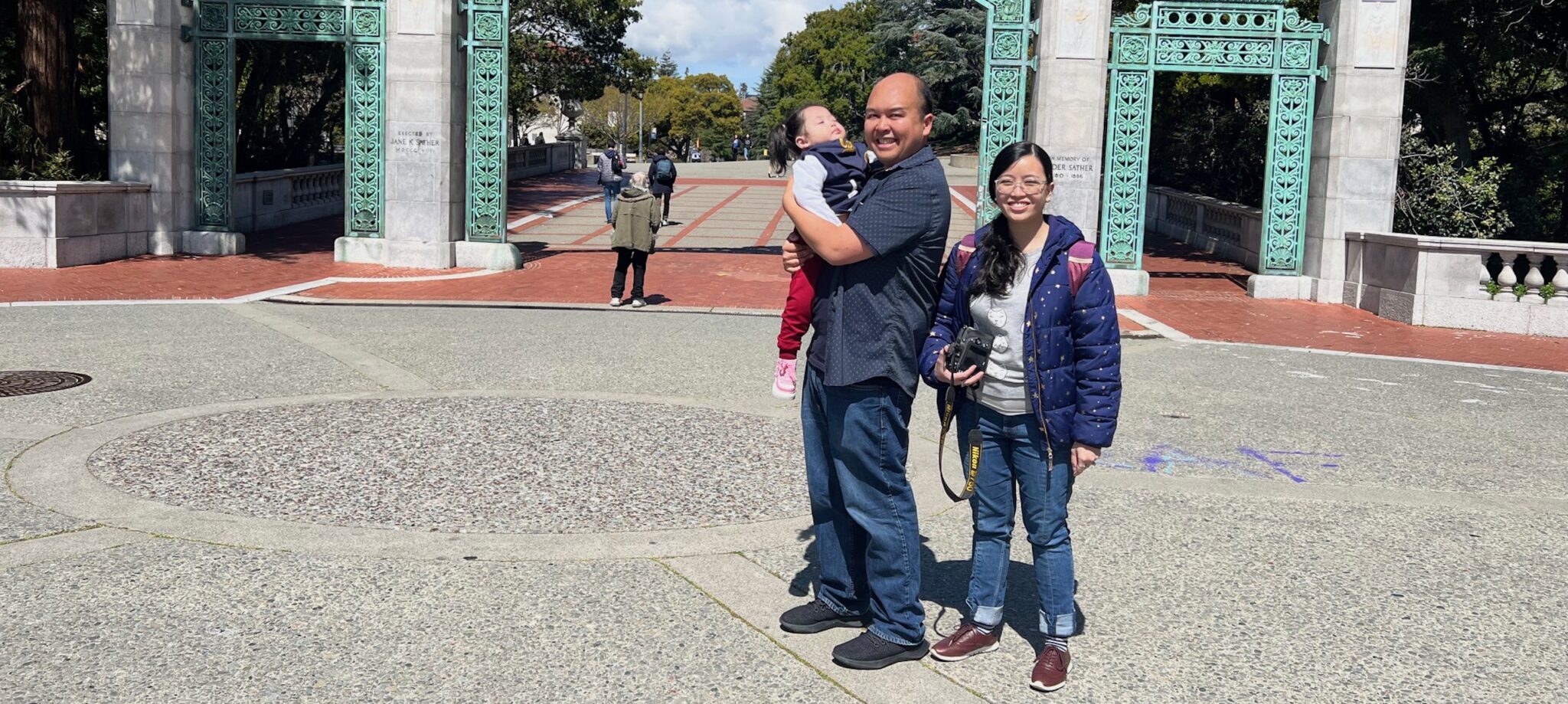 Parents with baby in front of Sather Gate