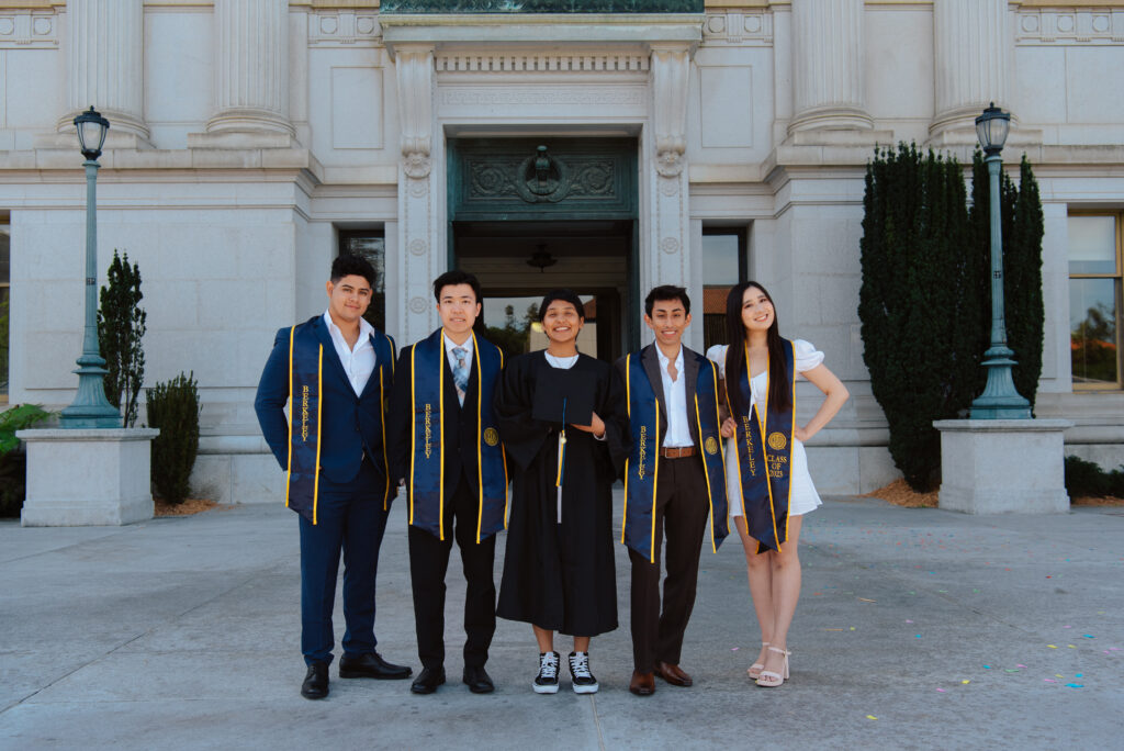 Five UC Berkeley graduates pose together.