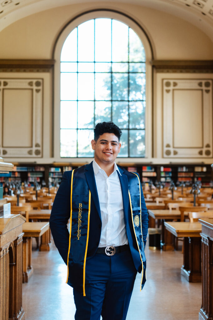 A UC Berkeley graduate poses inside the library. 