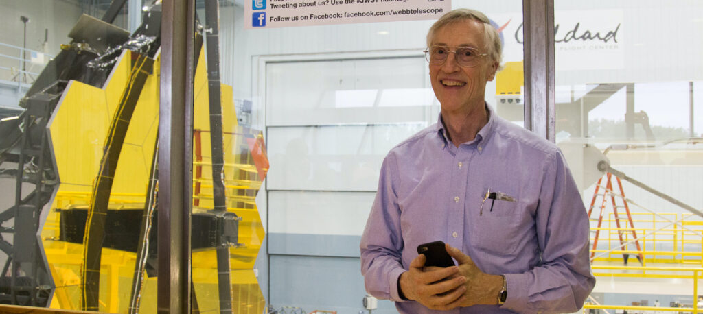 John Mather, Project Scientist for JWST, faces the James Webb Space Telescope primary mirror, NASA/Goddard Space Flight Center, Greenbelt, MD, May 4, 2016