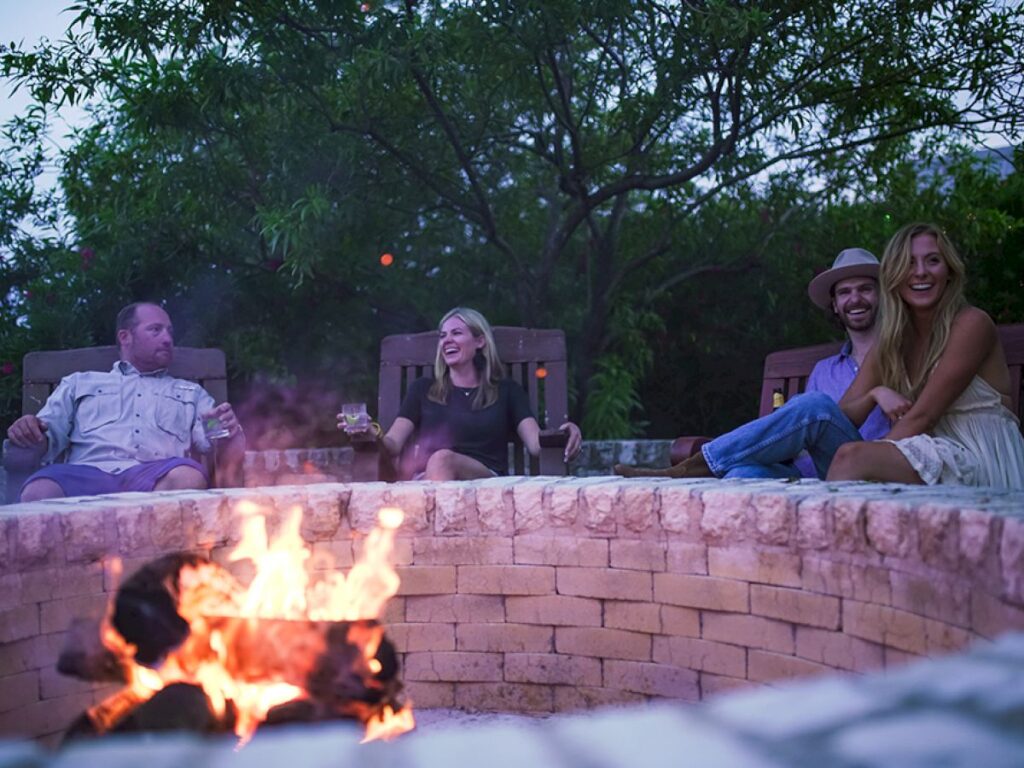 Guests at Rough Creek Lodge relax with beverages around one of two limestone fire pits.