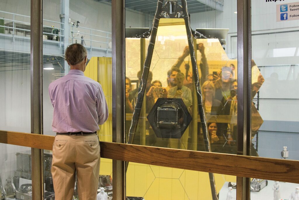 John Mather, Project Scientist for JWST, faces the James Webb Space Telescope primary mirror