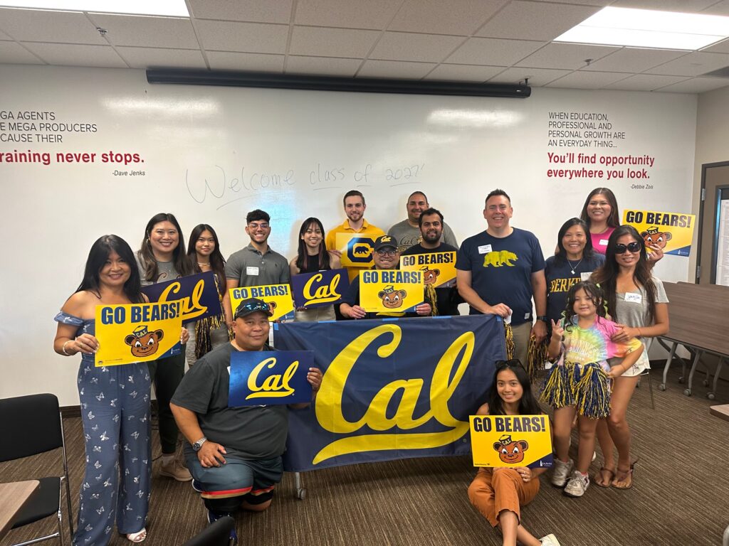 People at the Cal Alumni Chapter of Southern Nevada Summer Welcome Party pose with Cal banners and signs. 