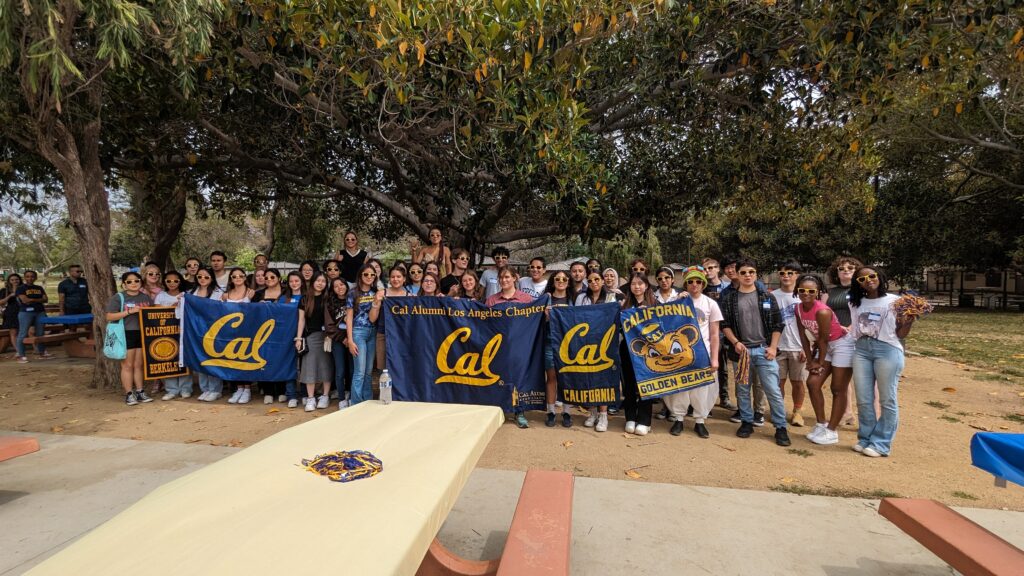 Attendees at the Cal Alumni of Los Angeles’ Summer Welcome Party pose with Cal flags. 