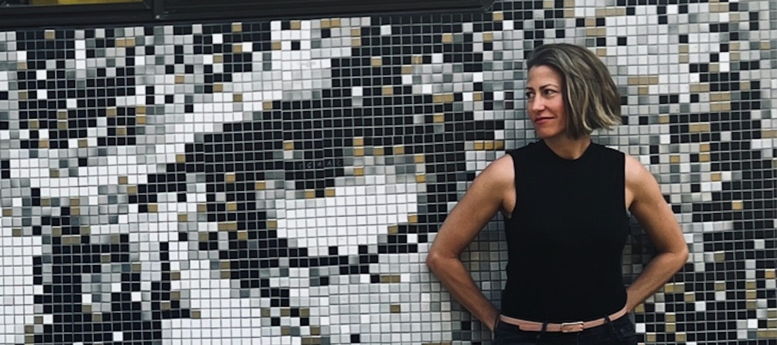 Cara Houser in front of a mural of an eye