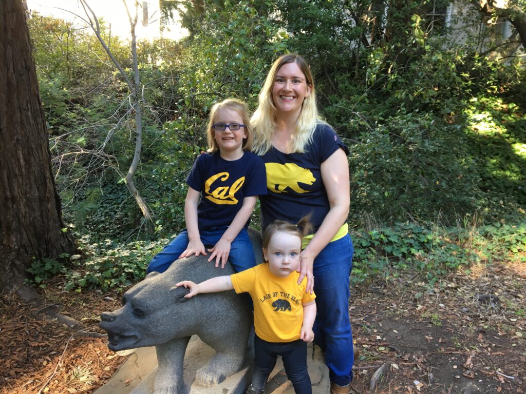 A family poses next to a bear statue at UC Berkeley. 
