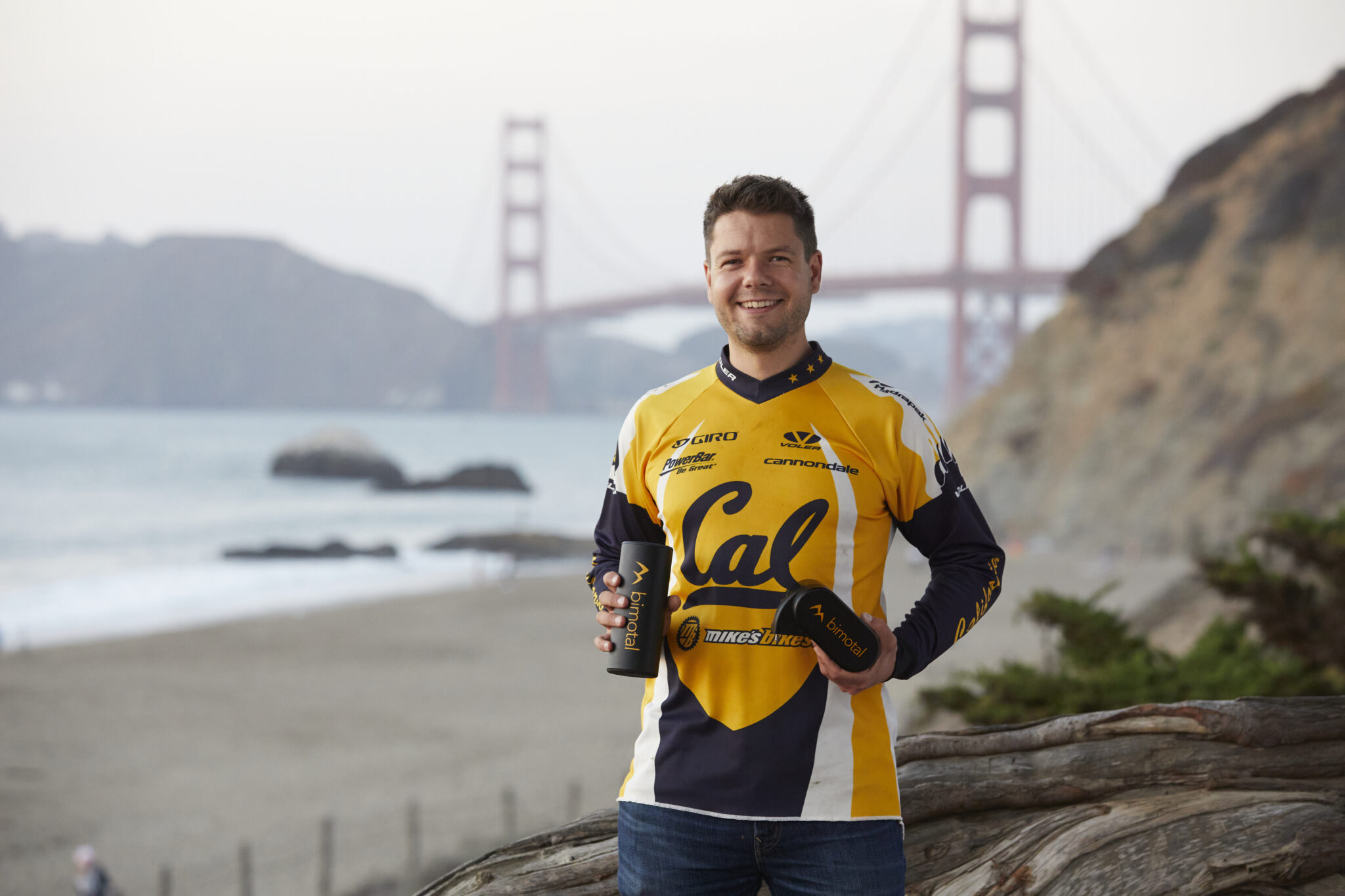 Toby Ricco stands on a beach with a view of the Golden Gate Bridge in the background.