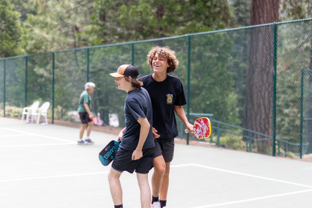 2 kids congratulating each other playing pickleball