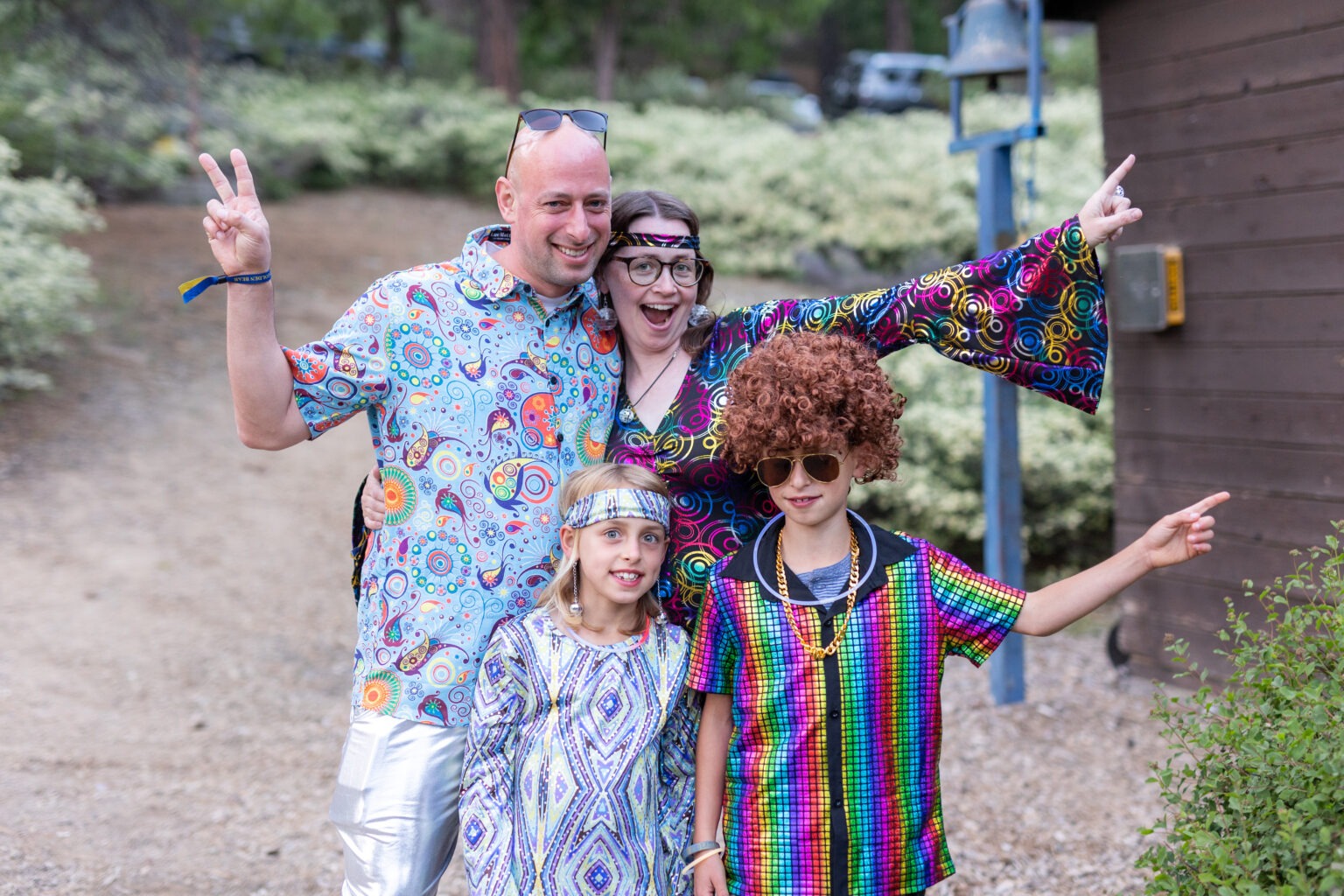 a family of 4 dressed up in disco costumes