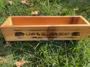 a wooden box to hold condiments, with the Lair of the Bear logo branded on one side.