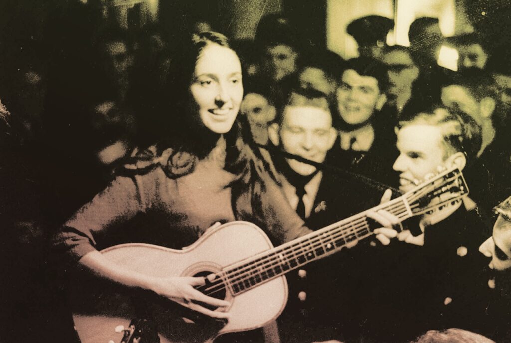 The "Princess" of folk singing, Joan Baez, wears the long hair and high-necked sweater which are trademarks of female folk singers, as she strums her guitar, Nov. 8, 1963.