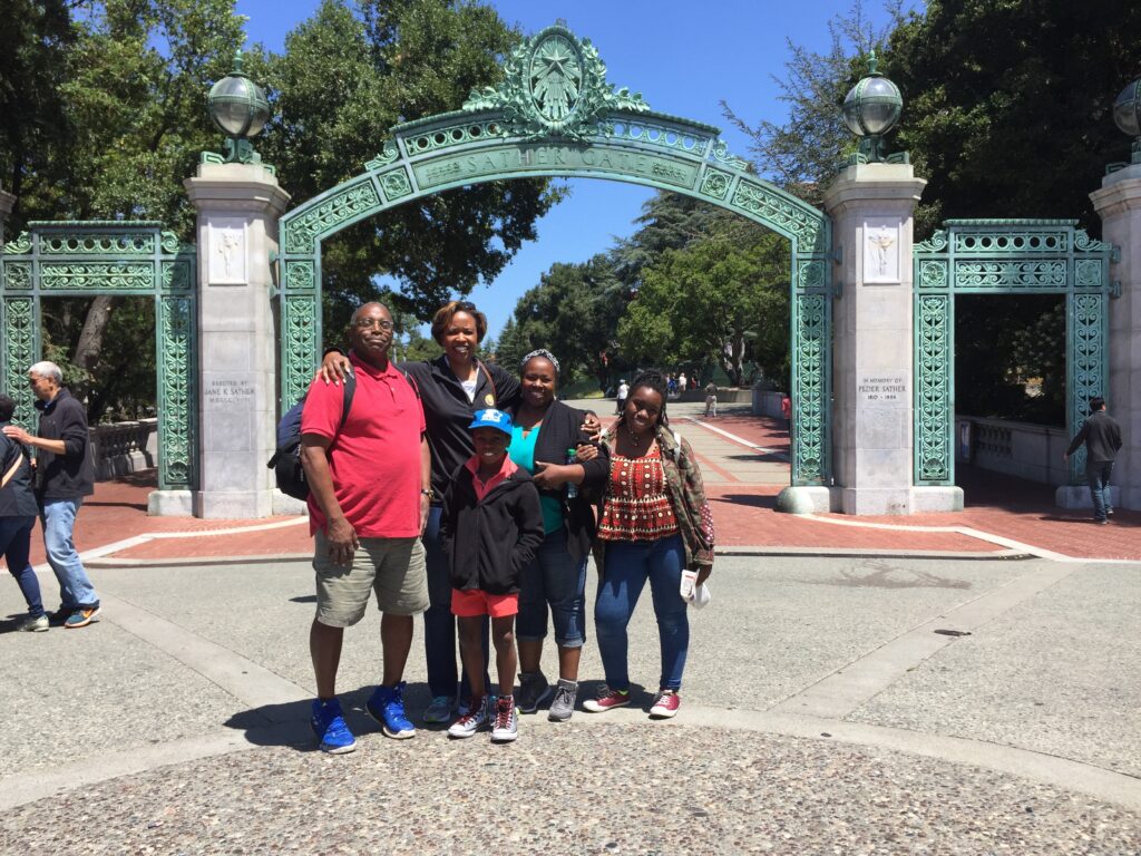Marsha Roberts and her family pose in front of Sather Gate.