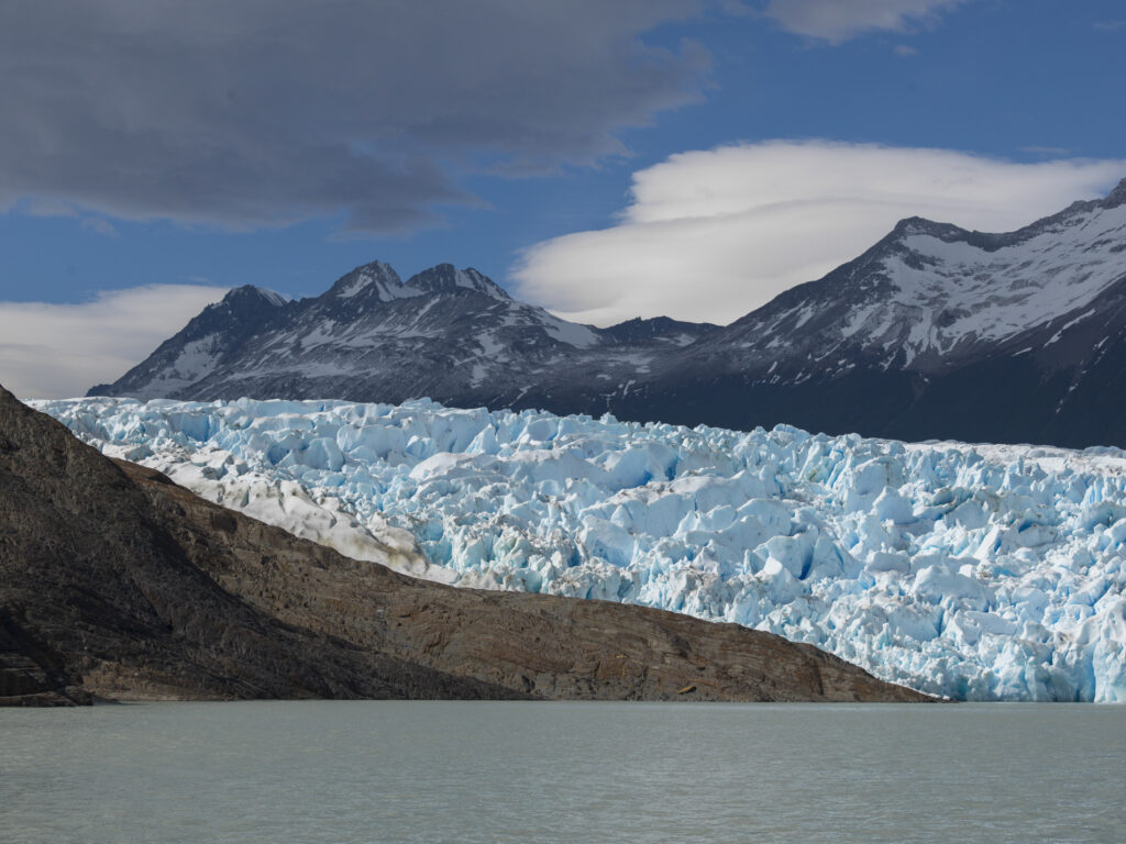 blue glacier against a mountainous backdrop