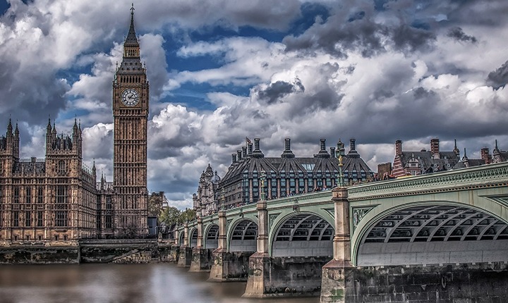 Big Ben clock tower and Westminster bridge with blue sky and puffy white clouds