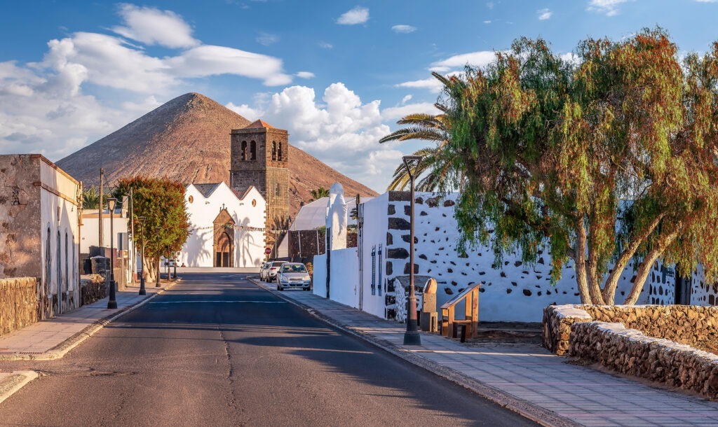 church at the end of a road with mountain backdrop in La Olivia in Canary Islands