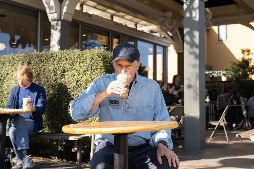 Daryl Ross sitting at Caffè Strada drinking a coffee.