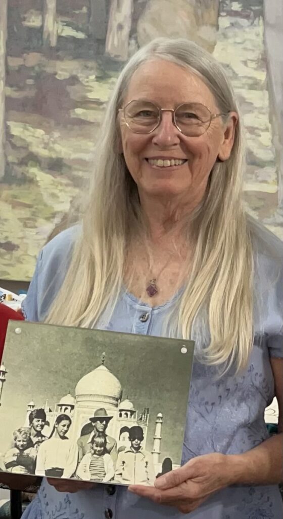 Susan smiles holding a picture