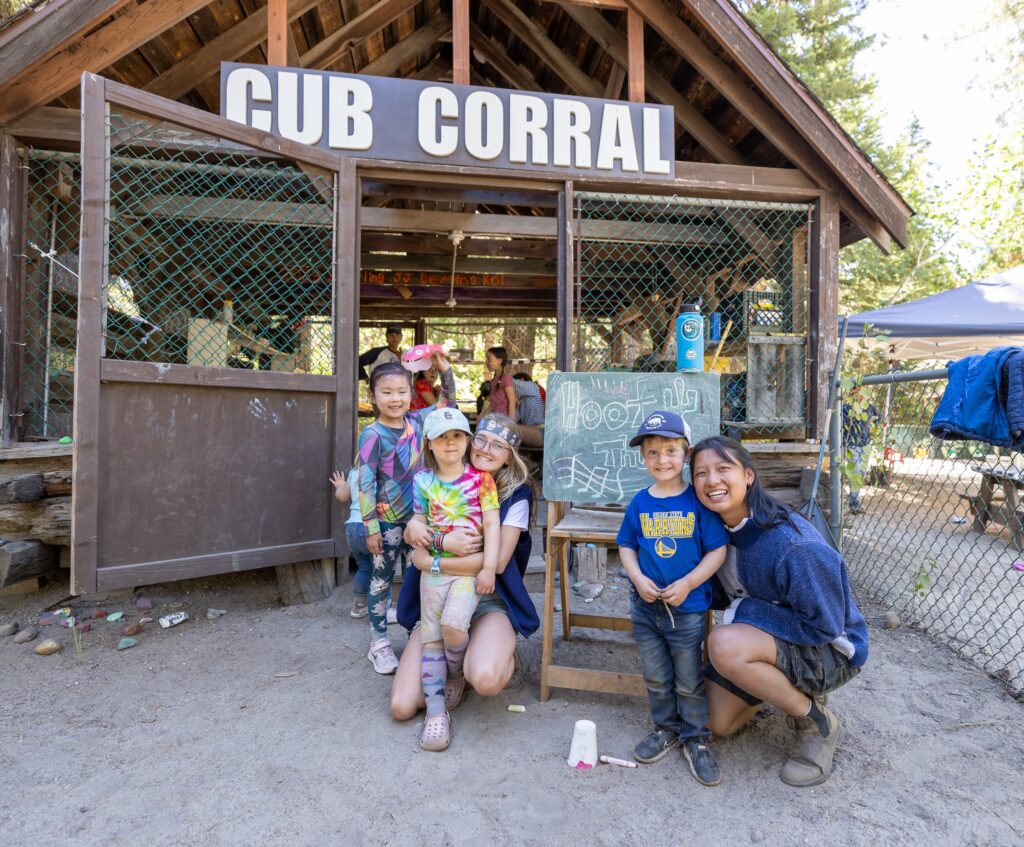 Young children and adults gathered together in front of the Cub Corral building