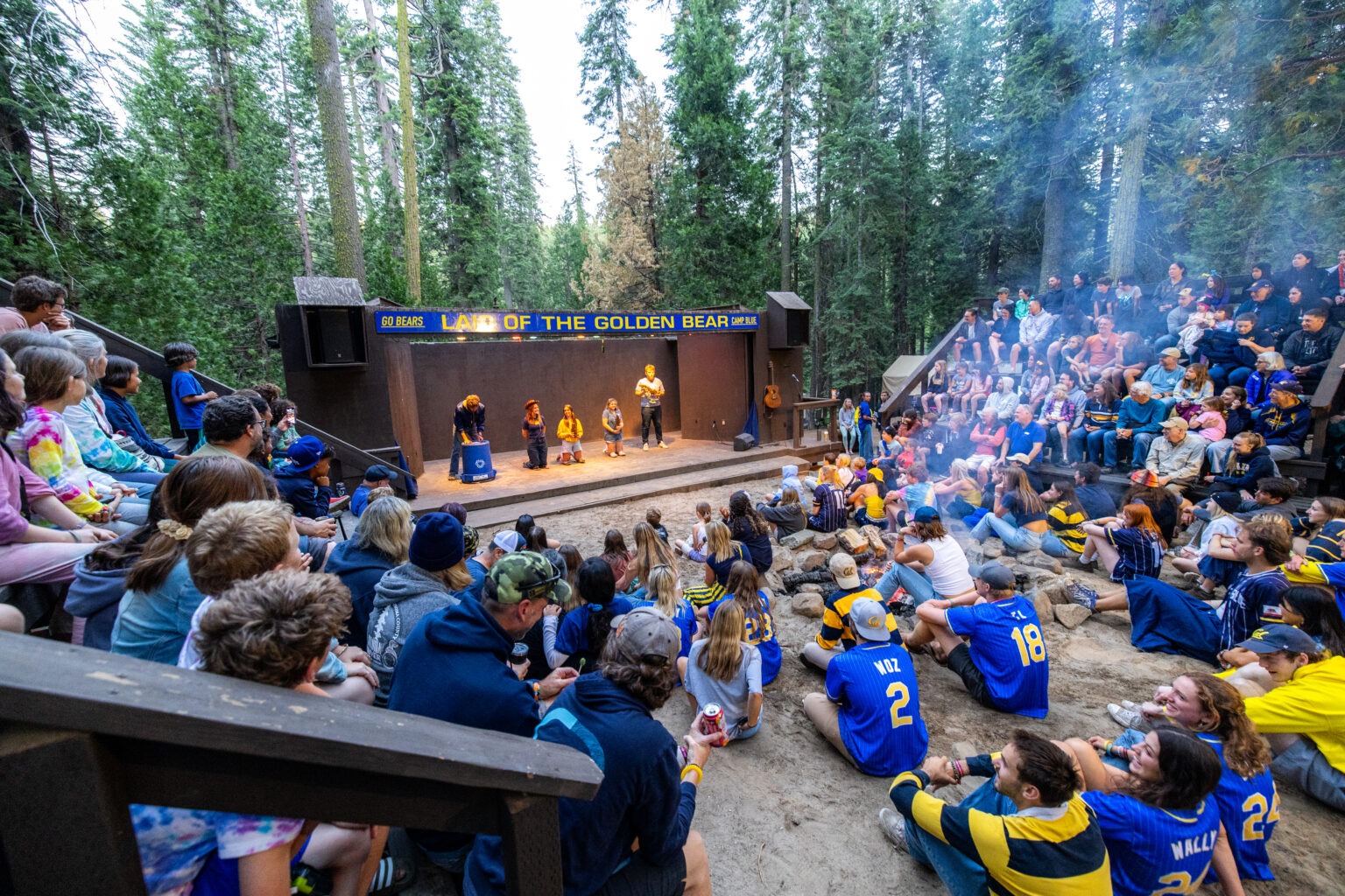 A view of a campfire show from up in the stands. Staffers are on stage and the bleachers are full.