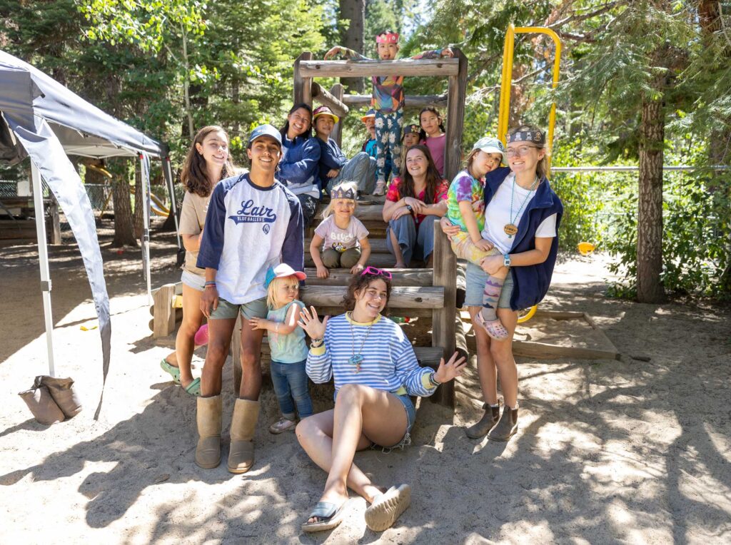 lair staff members and young campers smiling on the playground